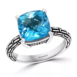 Effy Blue Topaz Statement Ring features a large, cushion-cut blue topaz mounted on an ornately designed silver band with a geometric pattern.