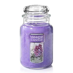 A large Yankee Candle jar in lilac color, labeled \“Lilac Blossoms,\“ featuring an image of lilac flowers.