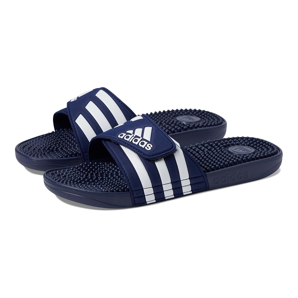 Navy Adidas Adissage slides with adjustable straps feature three white stripes and a cushioned footbed with massaging nubs for comfort.