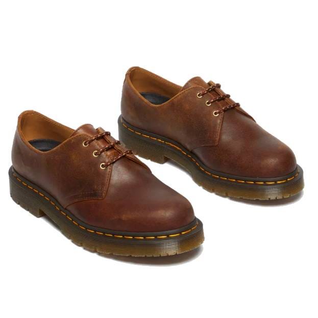 Brown leather lace-up shoes with a thick, ridged sole and signature yellow stitching.