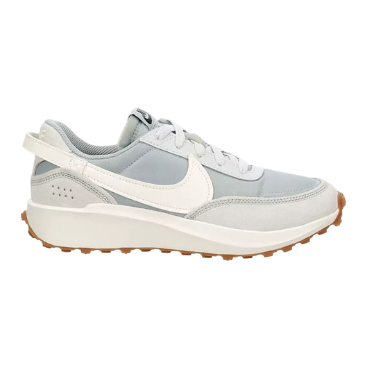 The Nike Waffle Debut is a casual sneaker featuring light grey and white tones with a leather and suede upper, signature Swoosh, and a textured waffle-patterned sole for traction.