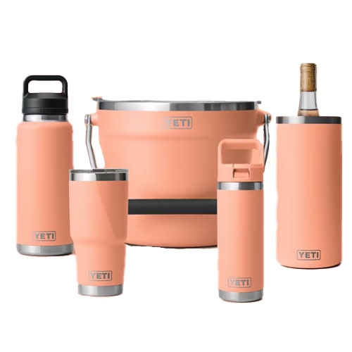 A collection of peach-colored YETI drinkware and a bucket, including a tumbler, water bottle, wine tumbler, wine chiller, and cooler bucket.