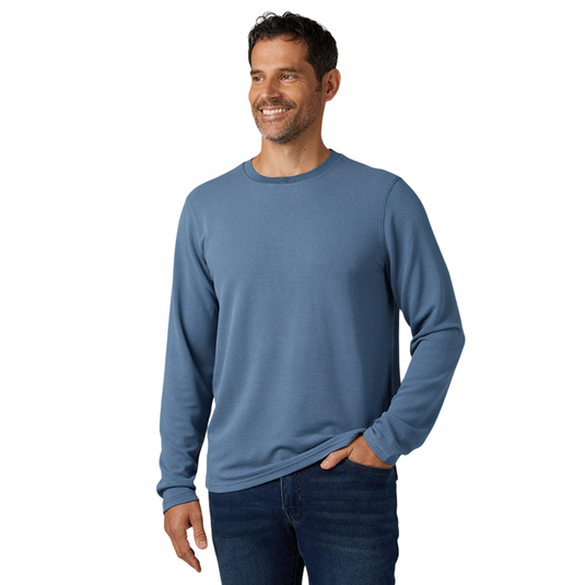 A man is wearing a long-sleeve blue shirt paired with dark blue jeans.