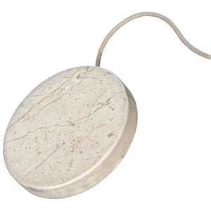 A wireless charging stone with a marble-like design and a fabric-wrapped cable.