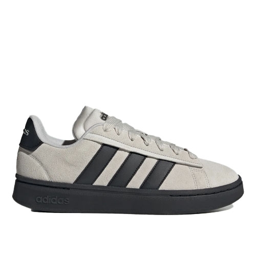 Adidas sneakers with a beige suede upper, black stripes, and a black sole.