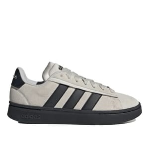 Adidas sneakers with a beige suede upper, black stripes, and a black sole.