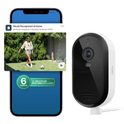 An Arlo security camera is shown alongside a smartphone displaying a notification and a captured video of a person recognized by the camera system.