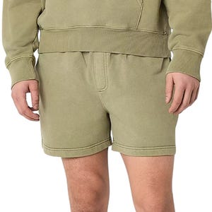 A person is wearing olive green shorts and a matching sweatshirt, both made of soft, textured fabric.