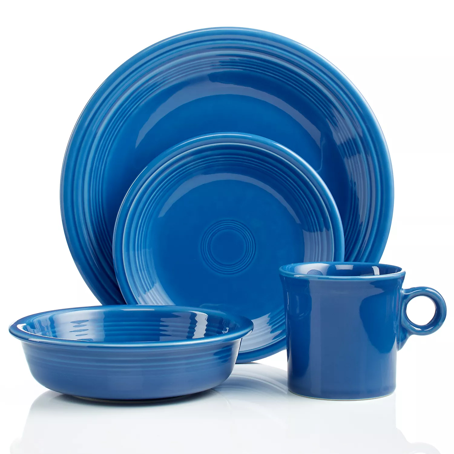 A blue dinnerware set includes a dinner plate, salad plate, bowl, and mug, each featuring a concentric circle design.