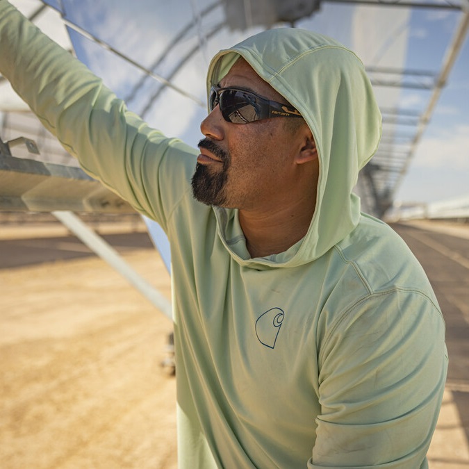 A man wearing sunglasses and a hooded long-sleeve shirt.