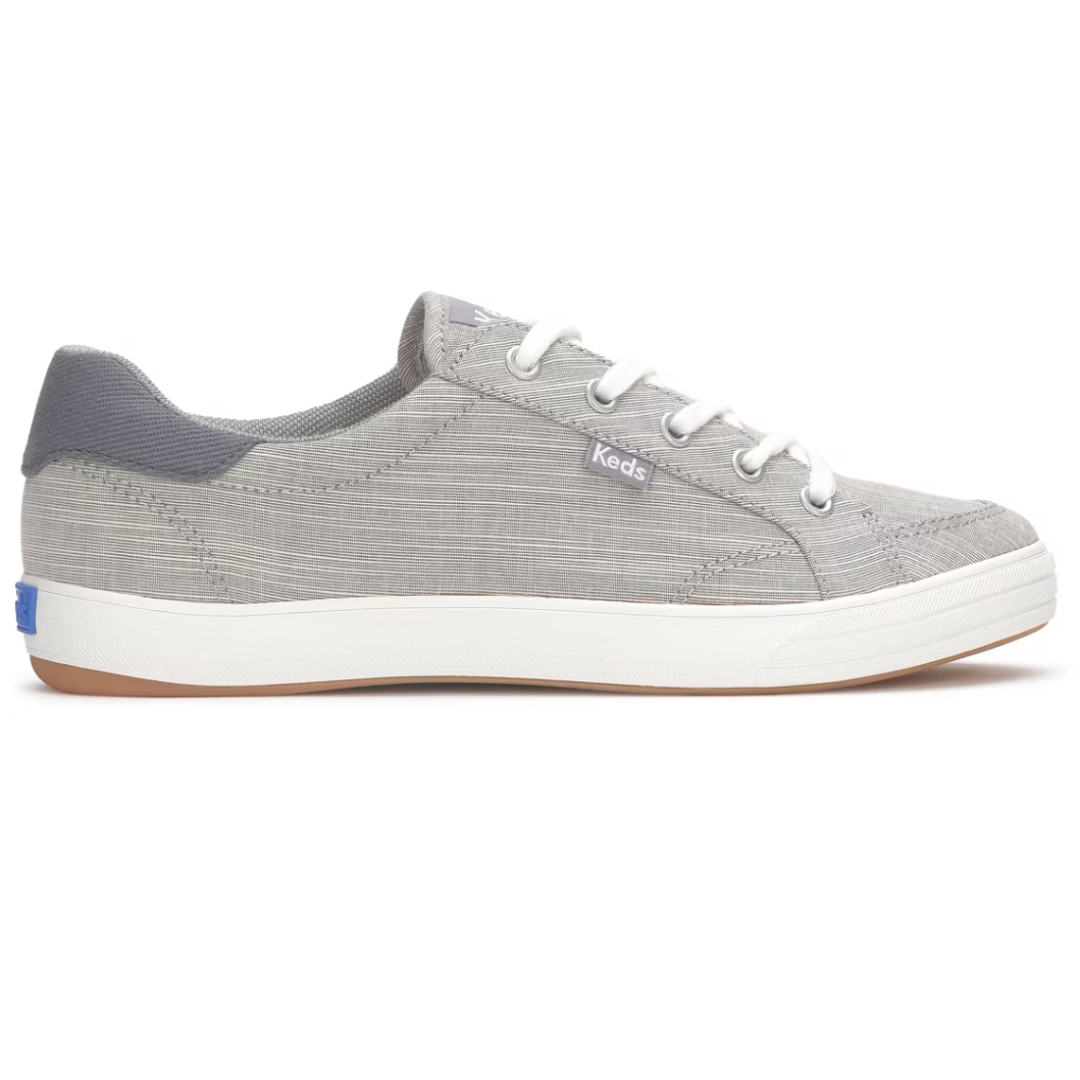 Gray Keds sneaker with white laces, a textured fabric, and white rubber sole.