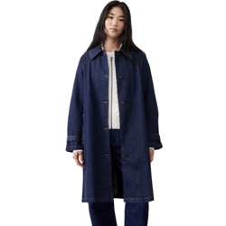 A person is wearing a long, dark denim coat over a white sweater, paired with matching denim pants and black loafers.