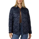 A woman is wearing a navy quilted jacket with snap buttons and front pockets, paired with blue pants.