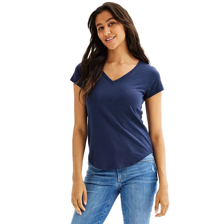 A woman is wearing a navy blue V-neck T-shirt paired with blue jeans. The T-shirt has short sleeves and a slightly curved hem.
