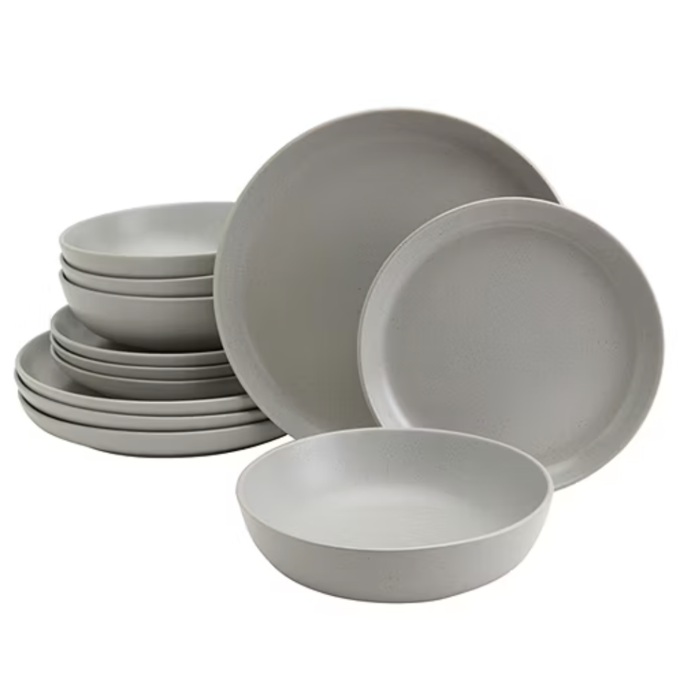 A set of minimalist gray dinnerware including plates and bowls, each a uniform color and design, neatly stacked together.