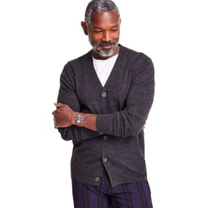 Dark gray V-neck cardigan with long sleeves and buttons down the front; paired with a white T-shirt and striped pants.