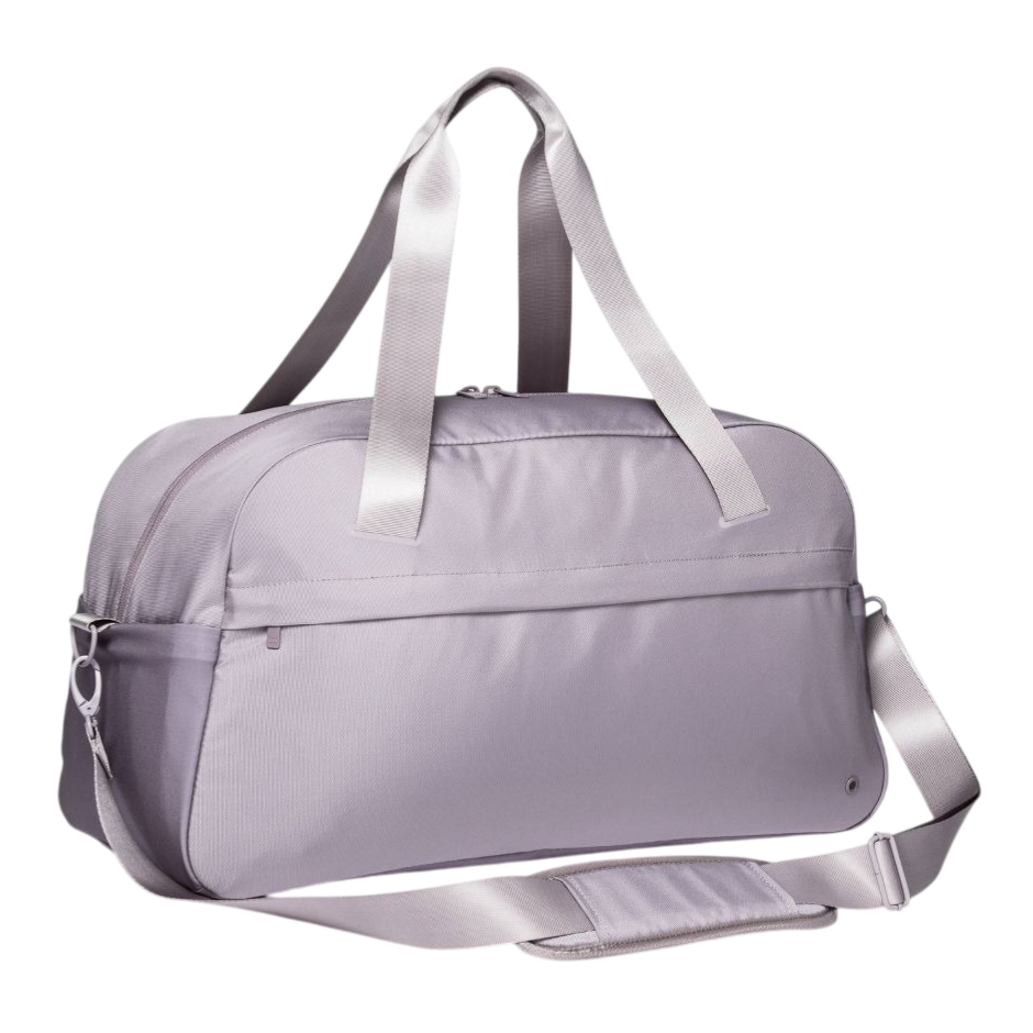 A light purple duffel bag with dual handles and an adjustable shoulder strap, featuring a front pocket and zippered closure.