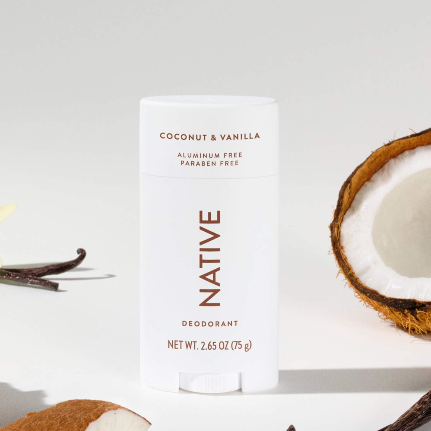 Native Coconut & Vanilla deodorant, 2.65 oz (75 g), is shown with pieces of coconut, vanilla beans, and a vanilla flower. The product is aluminum-free and paraben-free.