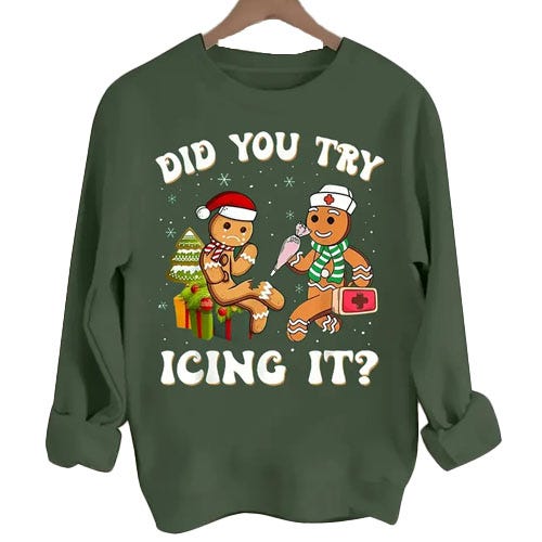 A green sweatshirt featuring a festive gingerbread-themed design with the text \“Did You Try Icing It?\“ showing one gingerbread character with an injured leg and another nursing it with icing.