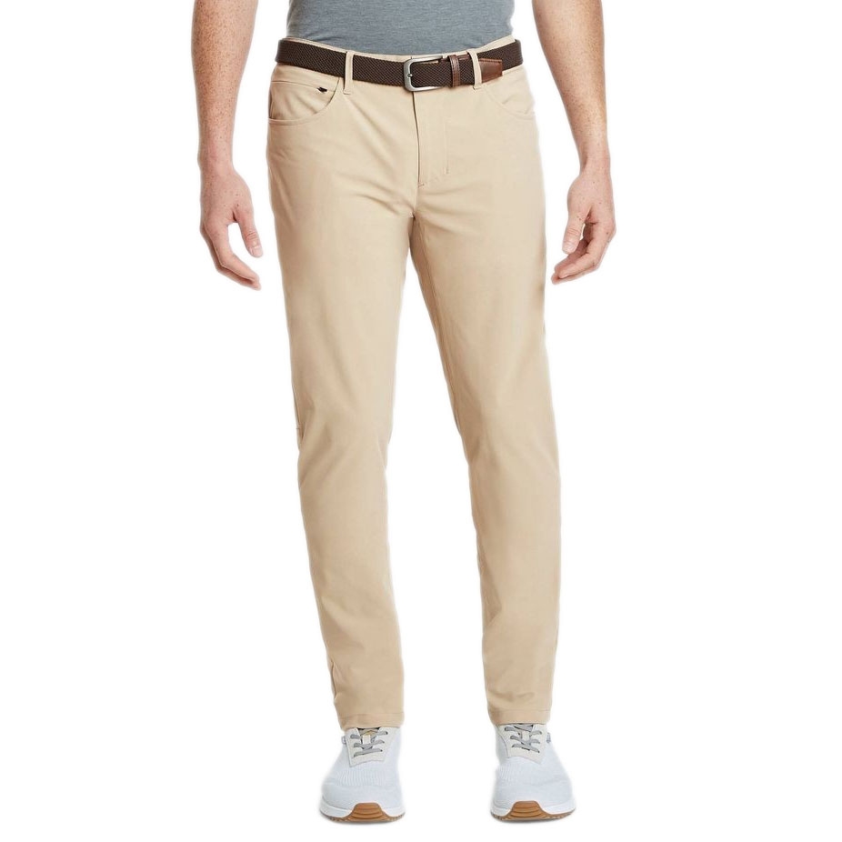 A person is wearing beige pants with a brown belt, gray shirt, and white sneakers.