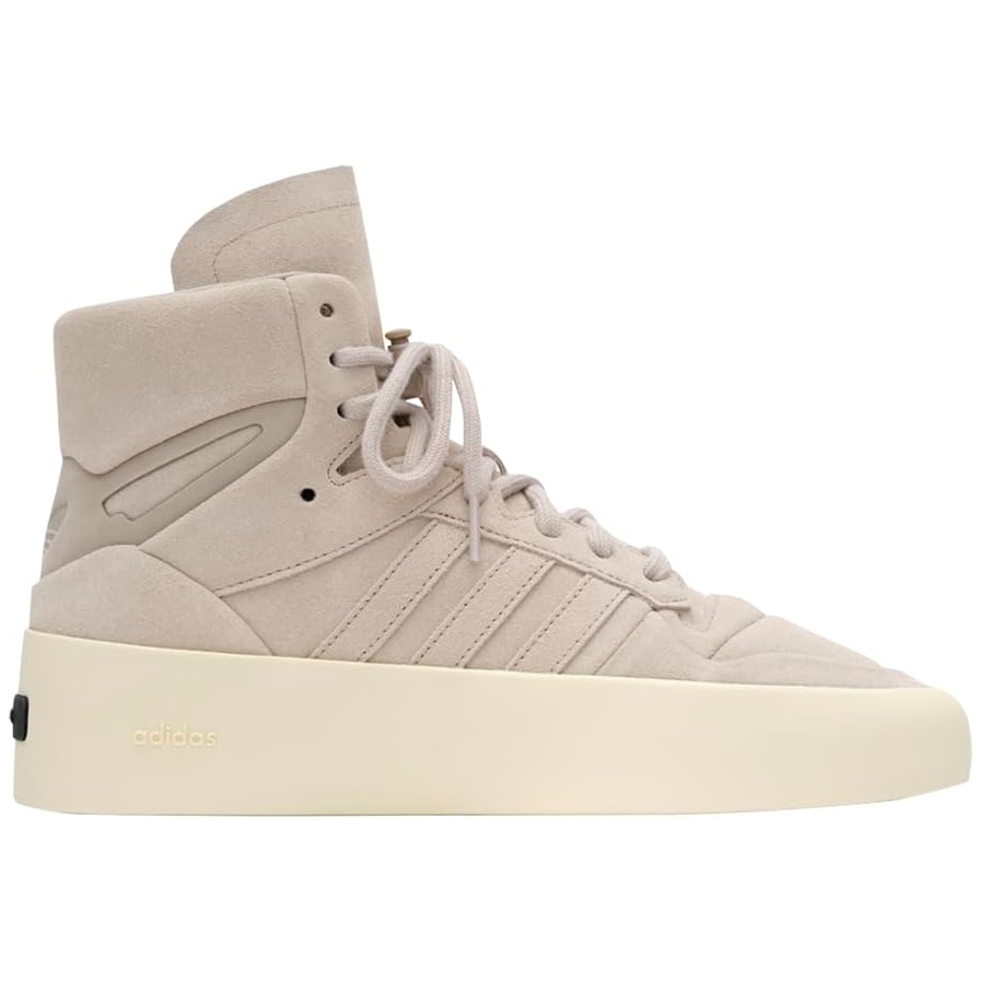 Adidas x Fear of God High Tops feature a beige suede upper with classic Adidas stripes, a high ankle support, and a cream rubber sole. The design includes minimal branding with \“adidas\“ embossed on the sole.