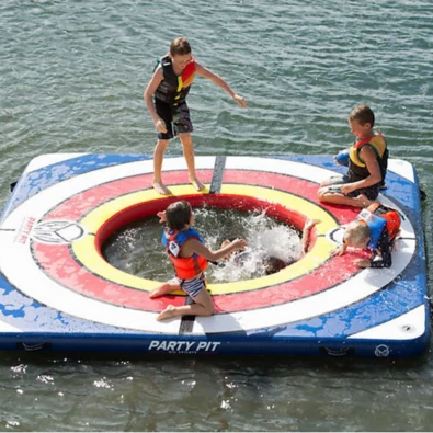 10' x 10' inflatable water party pad with a central cutout for water access, accommodating multiple people wearing life jackets; designed for recreational water play.