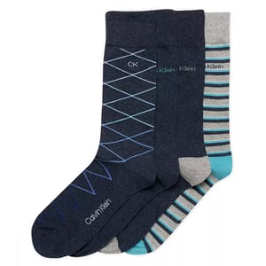 A set of three pairs of men's socks in various patterns, featuring blue diamond, solid with logo, and gray-blue striped designs. The socks display the Calvin Klein branding.