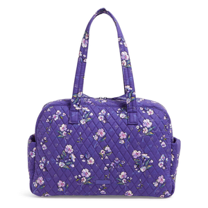 Purple quilted traveler bag with floral pattern, featuring two shoulder straps and side pockets for convenient storage.