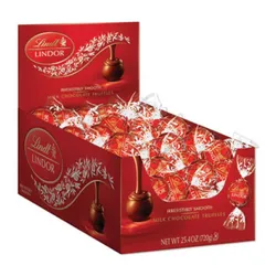 A display box of Lindt Lindor milk chocolate truffles, featuring individually wrapped red and white foil chocolates with the label \“irresistibly smooth.\“ Net weight: 25.4 oz (720g).
