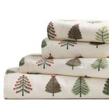 A stack of festive bed sheets with Christmas tree patterns in various designs and colors, displayed on a plain background.