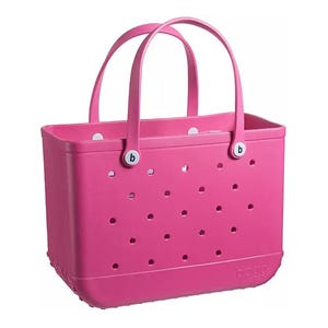 A pink tote bag with perforations and two handles, featuring a structured design suitable for carrying items.