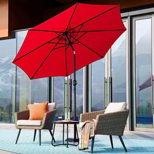 A red patio umbrella, two wicker chairs with cushions, a small round table, and an outdoor rug.