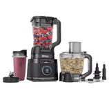 A Ninja multifunction kitchen appliance set includes a blender with berries, a smoothie cup, a food processor with chopped ingredients, and various attachments.