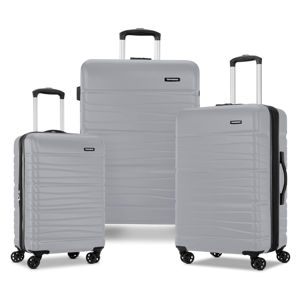 Three gray hard-shell suitcases with telescopic handles and four wheels are shown, varying in size for travel versatility.