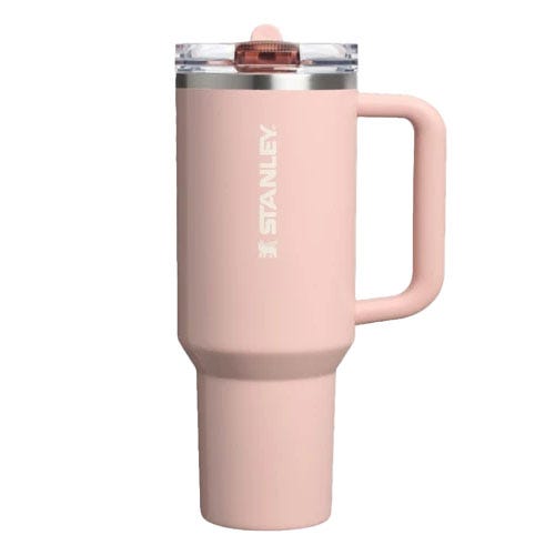 A pink Stanley travel mug with a handle and a clear lid.