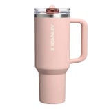 A pink Stanley travel mug with a handle and a clear lid.
