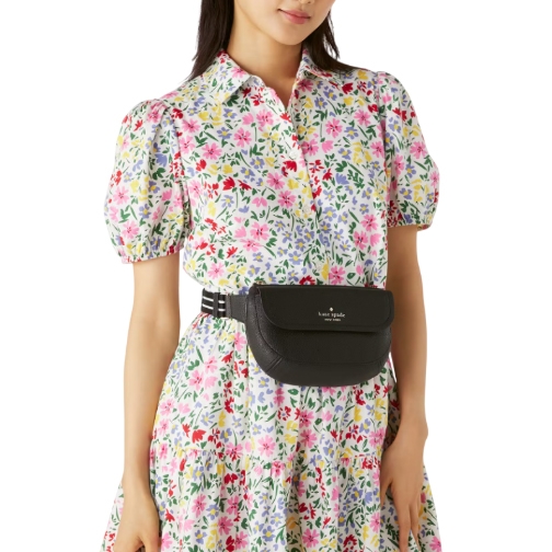A black leather belt bag with the Kate Spade logo in the center, featuring a sleek rectangular shape and an adjustable black strap.