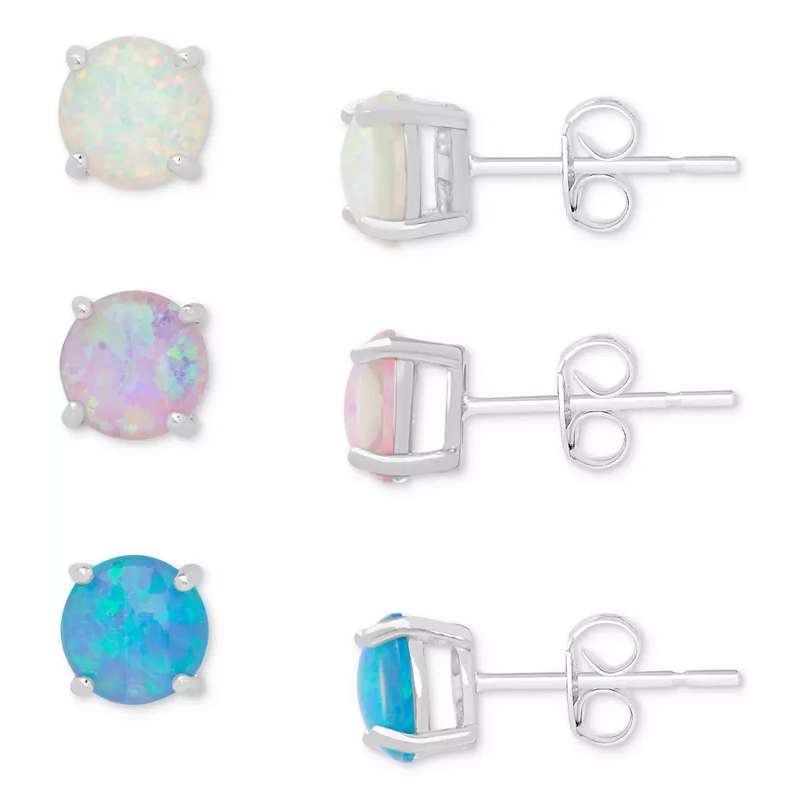 Set of three pairs of opal stud earrings in white, pink, and blue, each featuring round gemstones with four-prong silver settings and push backs.