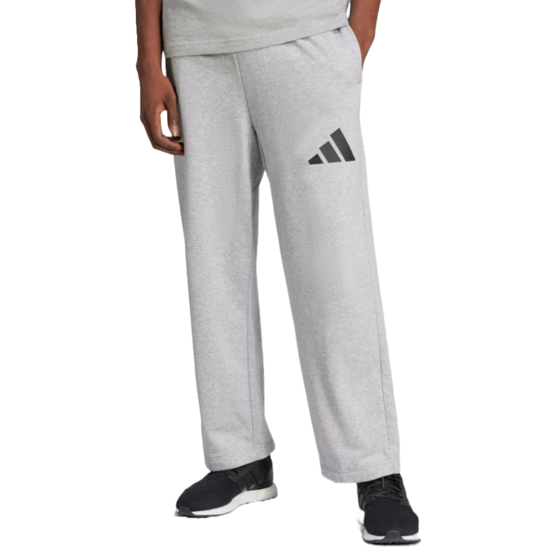 Adidas Wide Leg Lounge Pants feature a light gray color, a relaxed wide-leg fit, and the Adidas logo on the left thigh. They have an elastic waistband and side pockets, paired with black athletic shoes.
