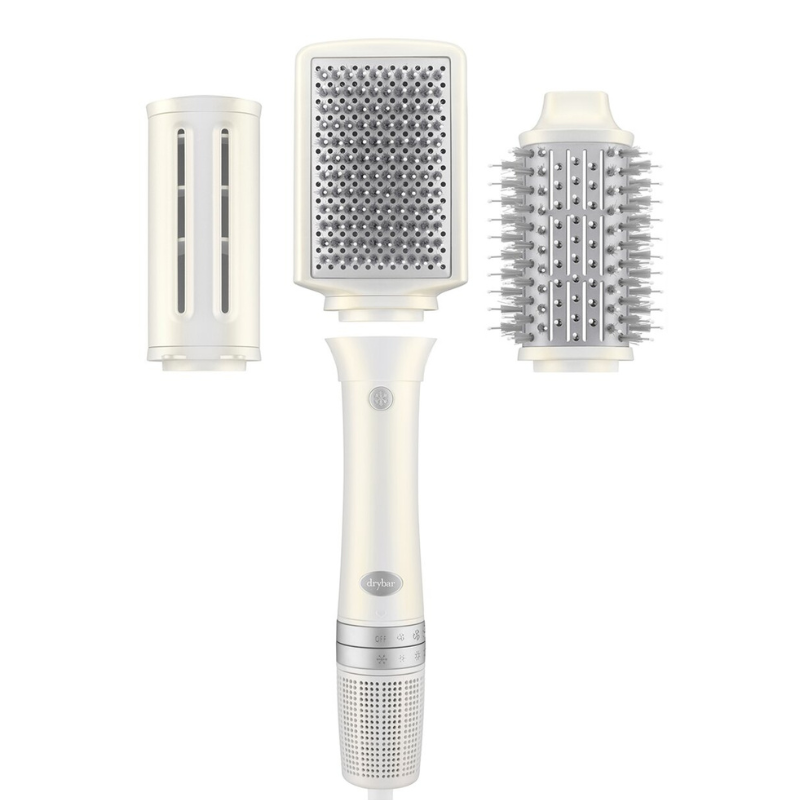 The 3pc Drybar Modular Hair Dryer features a handheld dryer with three interchangeable attachments: a flat brush, a vented barrel brush, and a round bristle brush, designed for versatile styling.