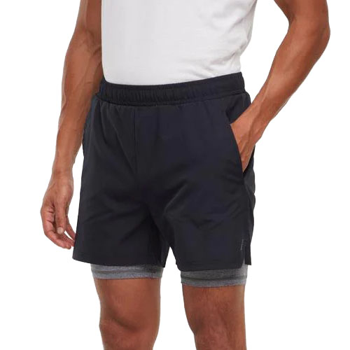 A person wearing black athletic shorts with an elastic waistband, layered over gray compression shorts.