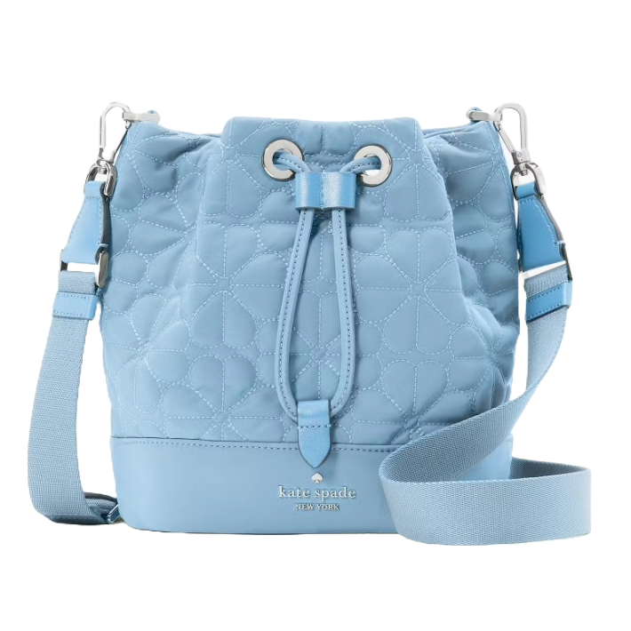 Light blue quilted bucket bag with a floral pattern, featuring a drawstring closure, adjustable shoulder strap, and silver hardware. Brand name and logo embossed on the front.