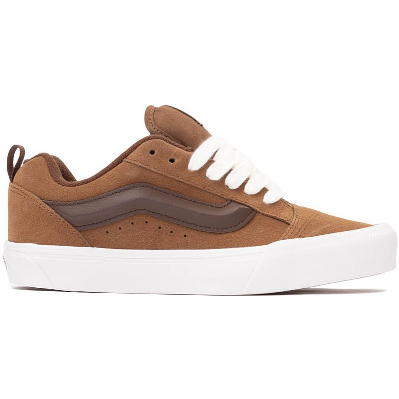 A brown suede skate shoe with a white sole, featuring a dark brown stripe on the side and white laces.