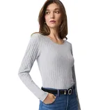 A woman wearing a light gray ribbed long-sleeve top paired with blue jeans and a black belt.