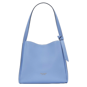 The Kate Spade Knott Large Shoulder Bag is a soft blue leather bag featuring a wavy top edge, a knotted strap detail, and the brand's logo in gold lettering on the front.