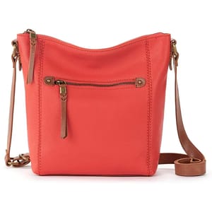 Coral leather crossbody bag with a front zipper pocket and brown adjustable strap.