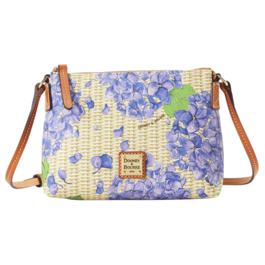 A crossbody bag with a floral design featuring purple hydrangeas, leather straps, and a Dooney & Bourke logo patch.