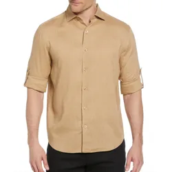 A beige long-sleeve shirt with roll-tab sleeves, button-up front, and a classic collar, worn with black pants.