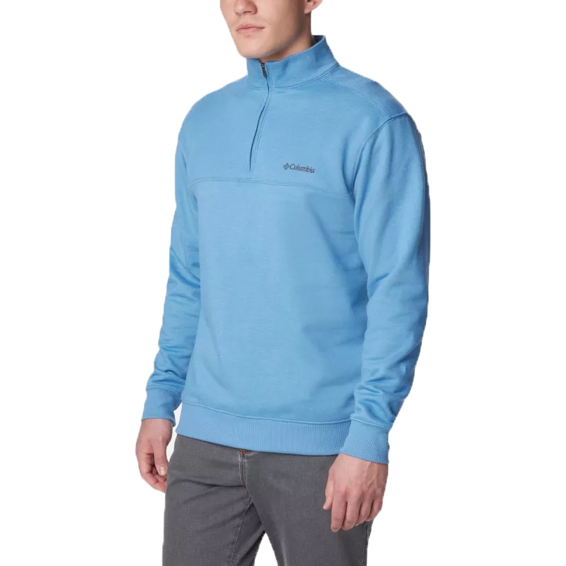 A man wearing a light blue half-zip fleece pullover with a small logo on the chest.