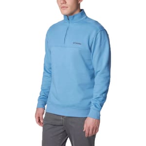 A man wearing a light blue half-zip fleece pullover with a small logo on the chest.